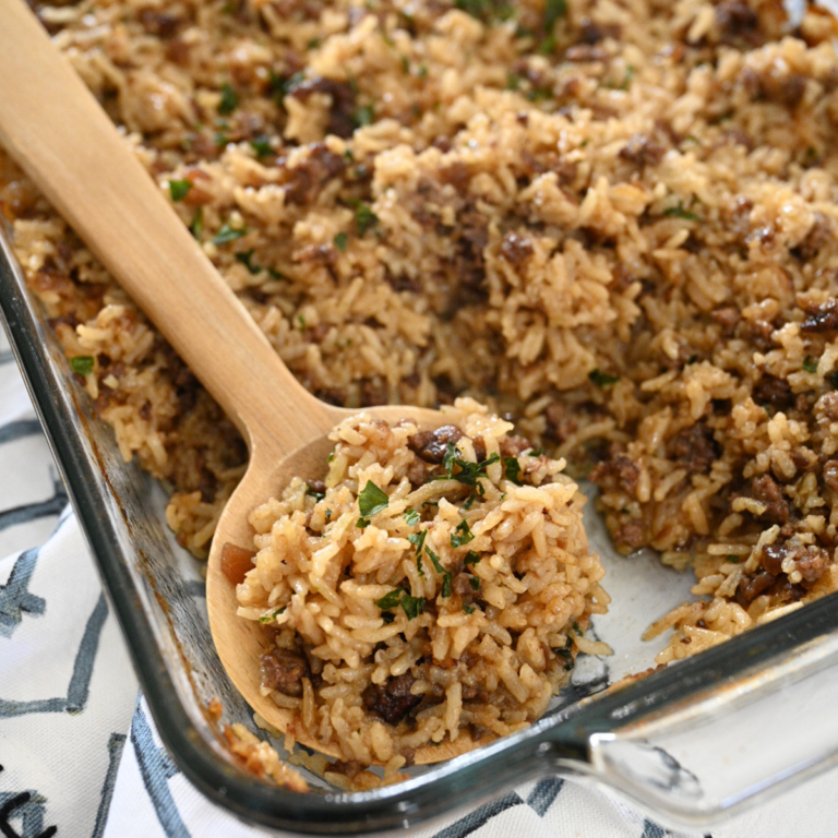 French onion casserole scooped out of dish with a wooden spoon.