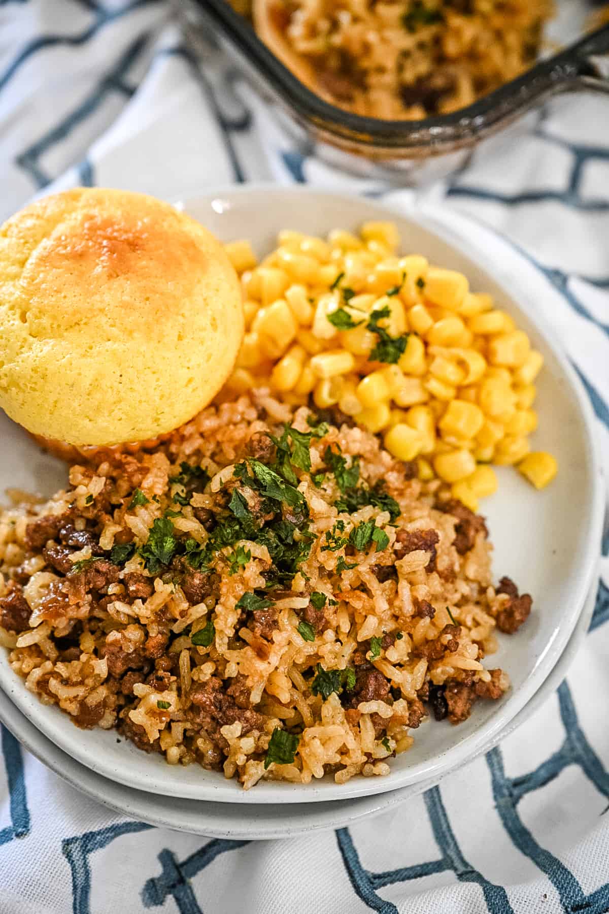 Hamburger and rice onion soup casserole plated with corn and a cornbread muffin.