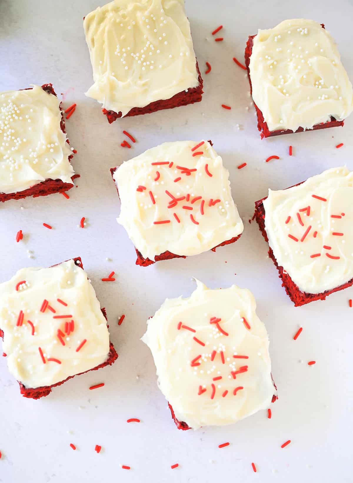 Overhead view of red velvet brownies scattered on a tray.