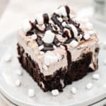 Chocolate poke cake with a fluffy hot chocolate infused whipped topping. Drizzled with chocolate fudge and mini marshmallows.
