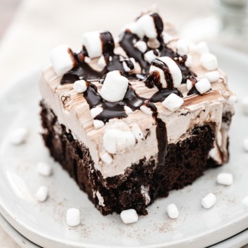 Chocolate poke cake with a fluffy hot chocolate infused whipped topping. Drizzled with chocolate fudge and mini marshmallows.