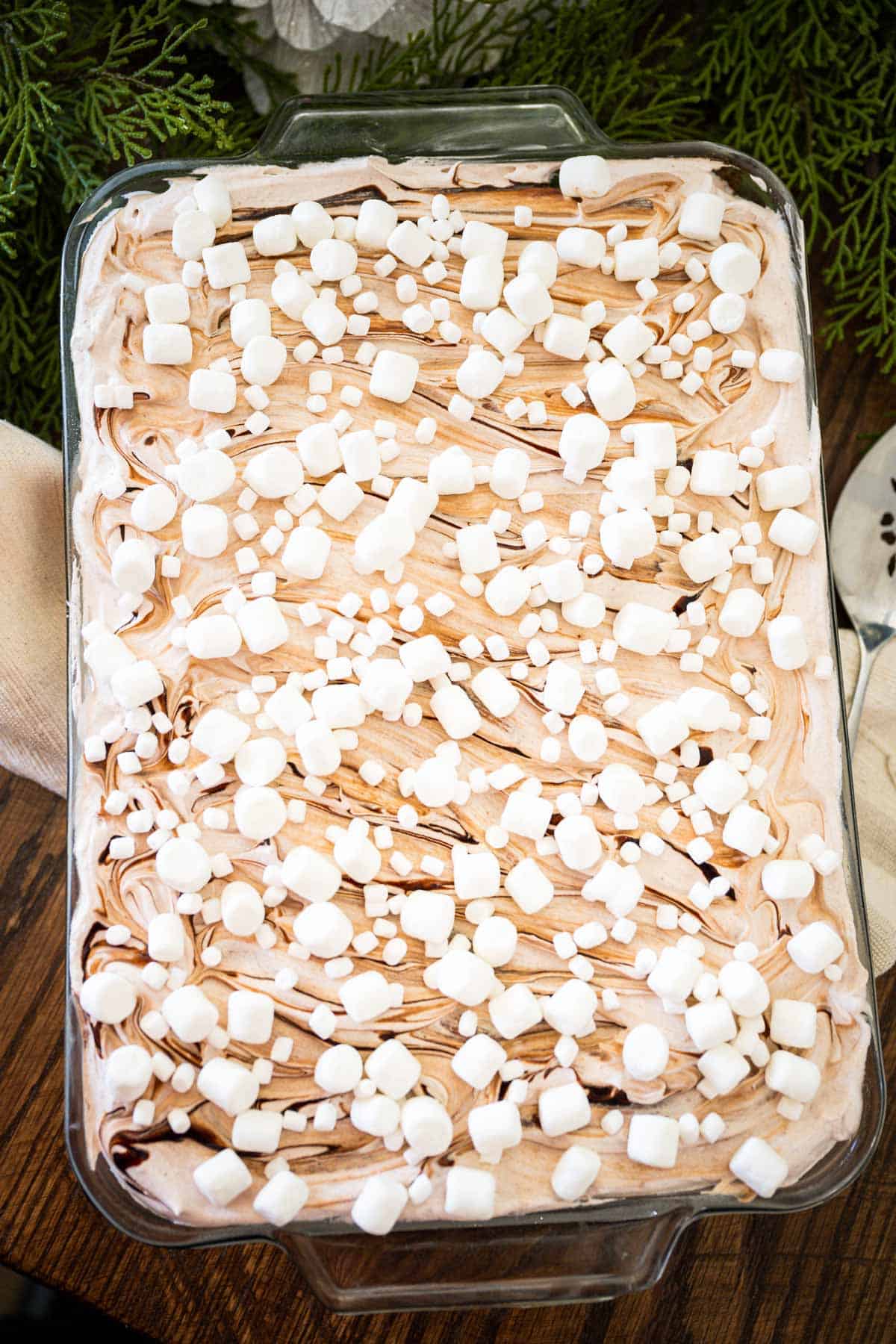 Overhead image of hot chocolate cake in a glass 9 X 13 dish with chocolate swirled around and marshmallows on top.