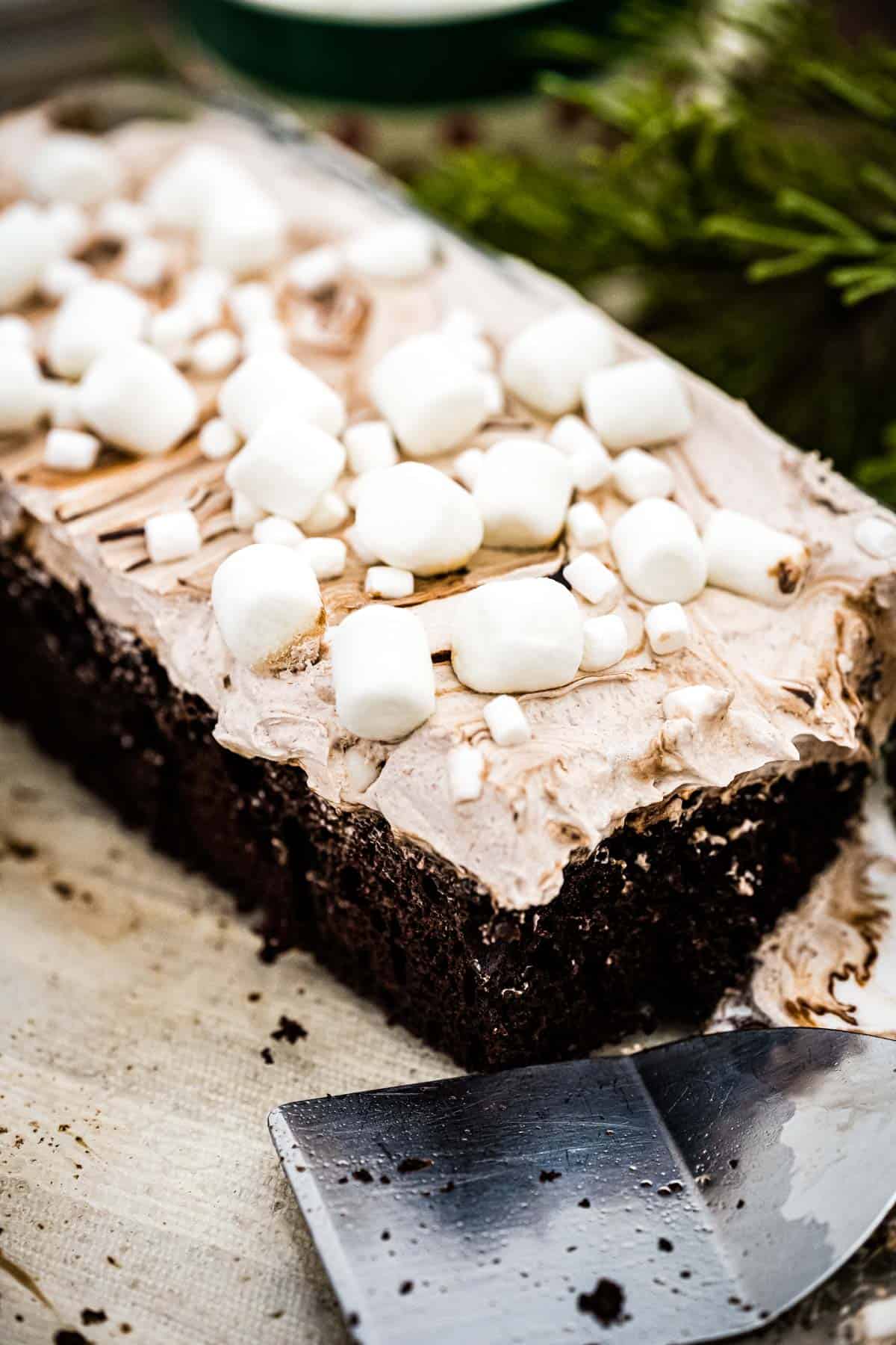 Partially cut whole hot chocolate cake with a cake server in the foreground.