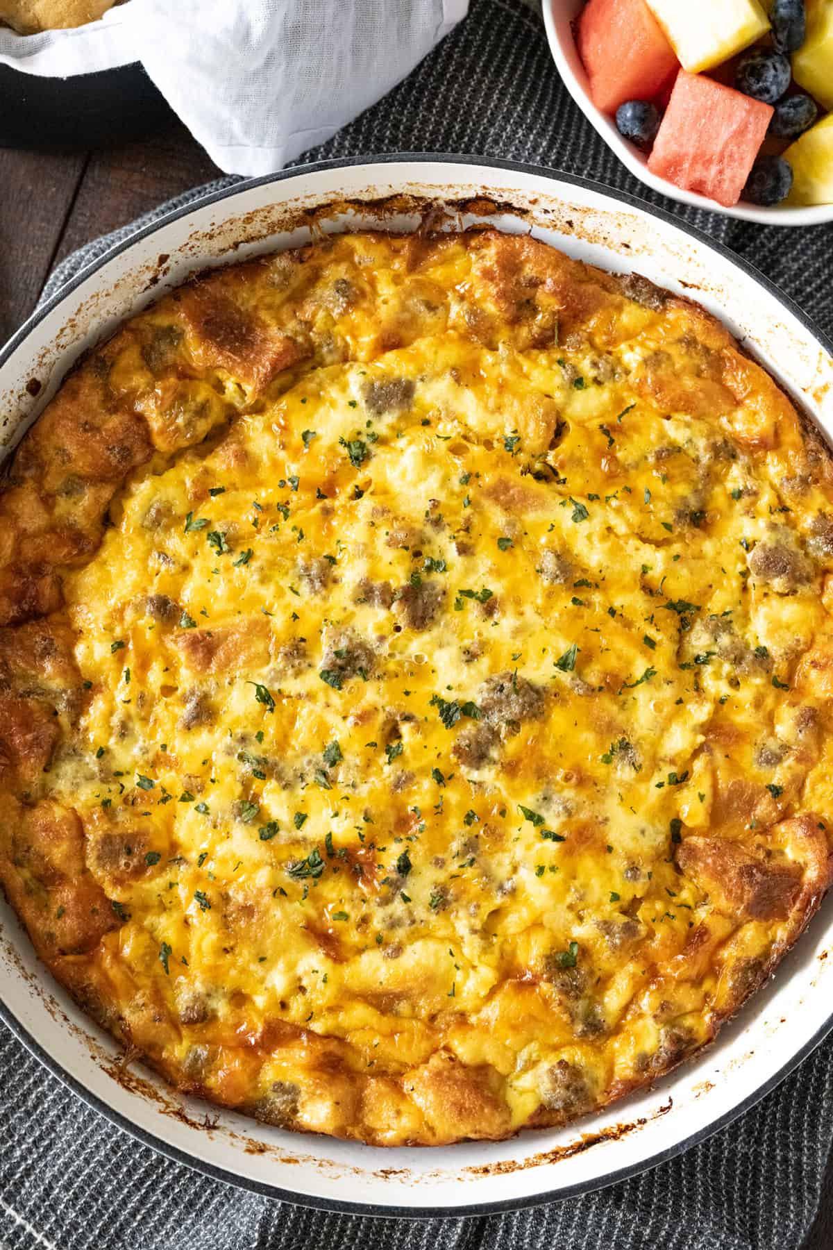 Overhead image of a sausage breakfast casserole in a white round enameled cast iron pan.