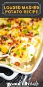 A close up shot of the Loaded Mashed Potato Recipe in a rectangle casserole dish. Topped with cheese, bacon and chives.