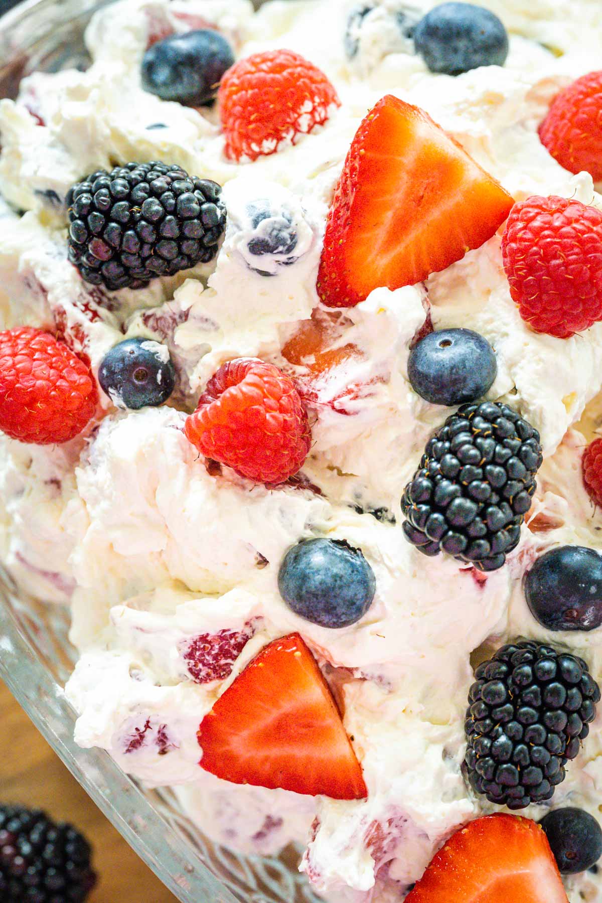 Up close image showing creamy cheesecake filling and fresh berries that make up a berry cheesecake salad recipe.