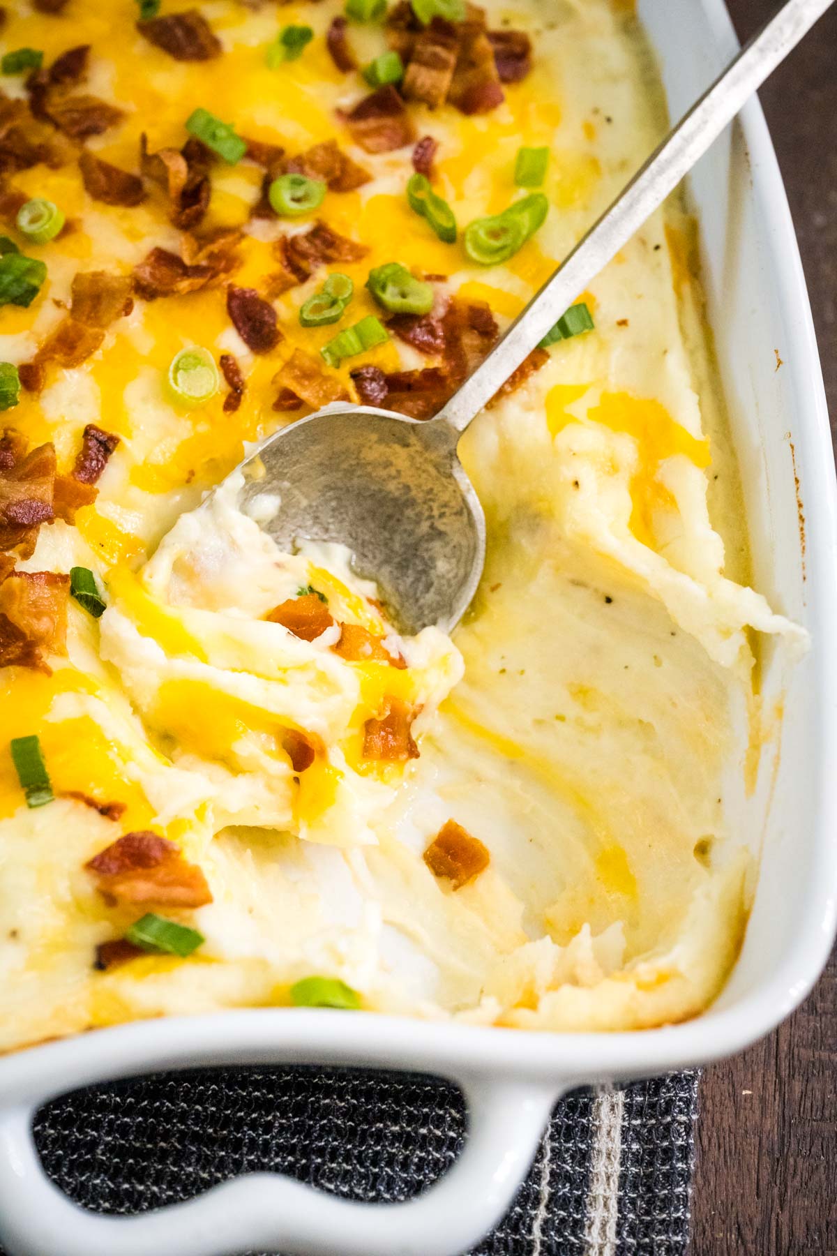 A casserole filled with mashed potatoes loaded with cheese and bacon.