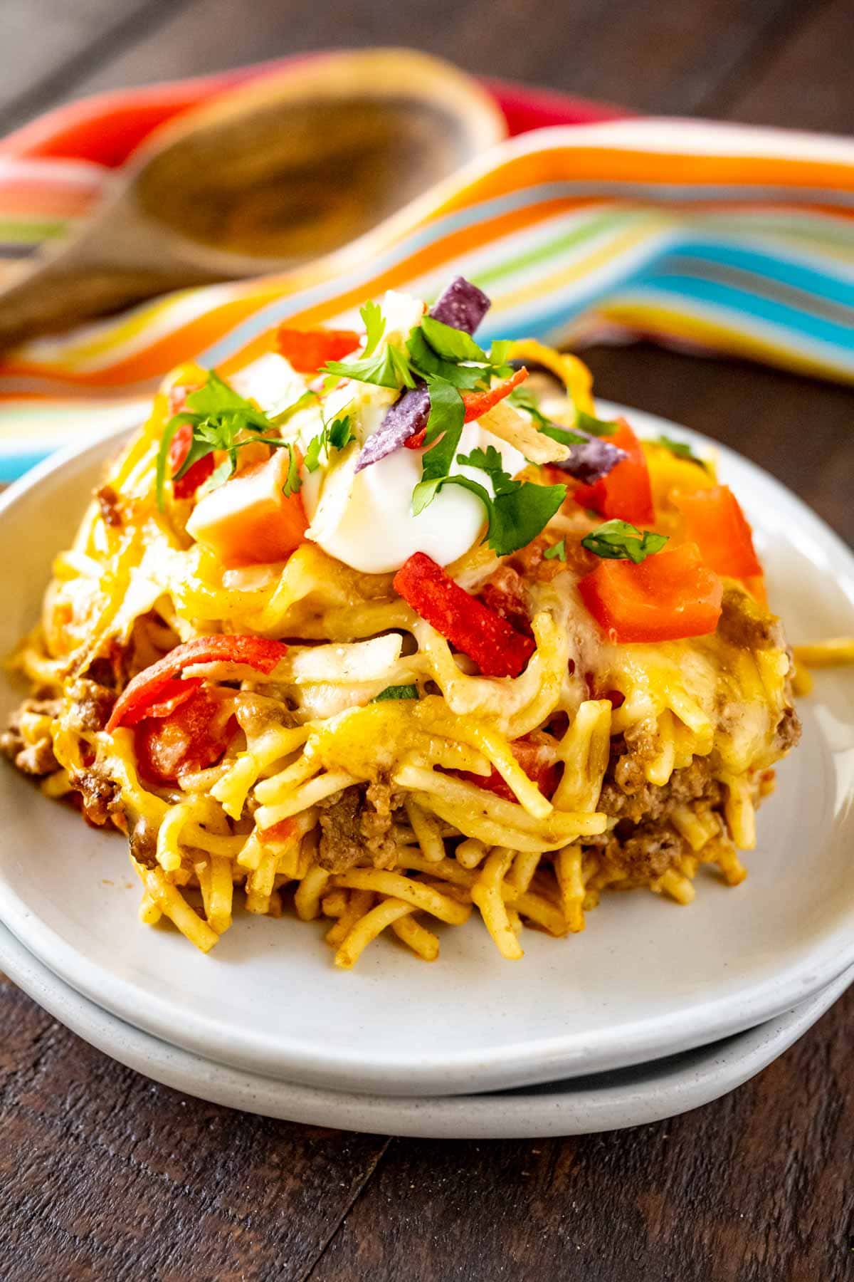Mexican Spaghetti Pasta plated and topped with sour cream, tomatoes, tortilla strips, and cilantro.