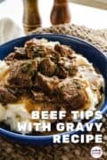 Beef Tips with Gravy Recipe- a decorative image of the meal in a blue bowl on the table with salt and pepper in the background.