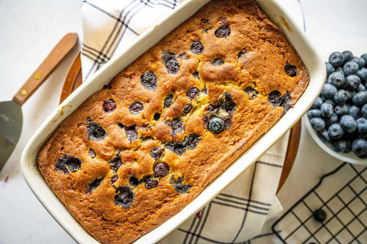 A loaf of blueberry banana bread in a loaf pan.