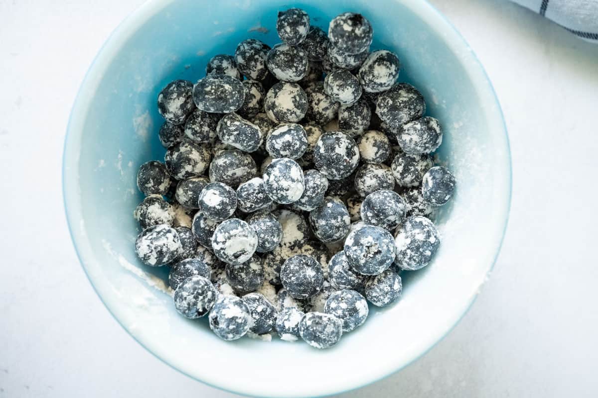 Bowl of whole blueberries tossed with flour.