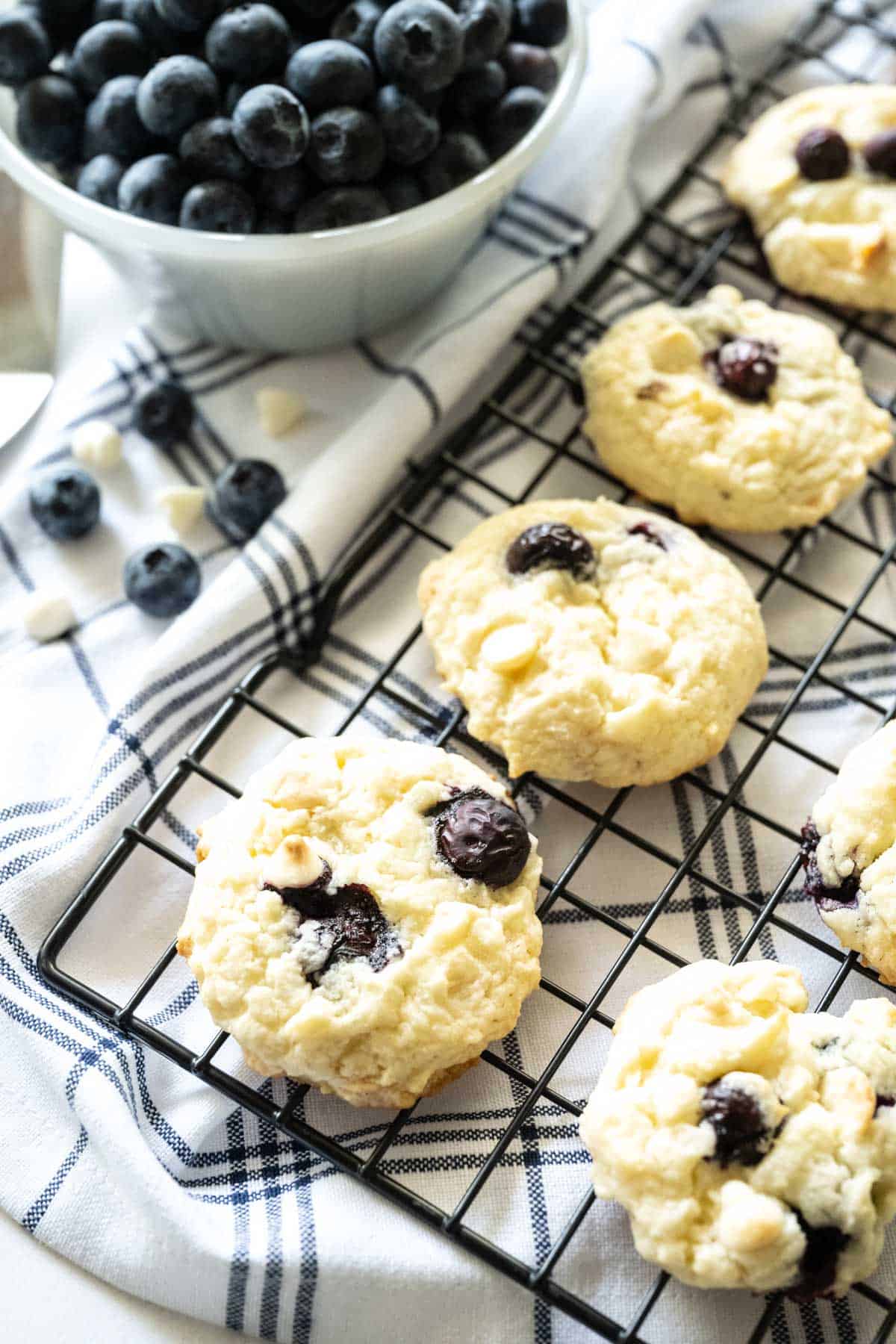 Blueberry Cheesecake Cookies on a cooling rack with a blue and white cloth underneath.