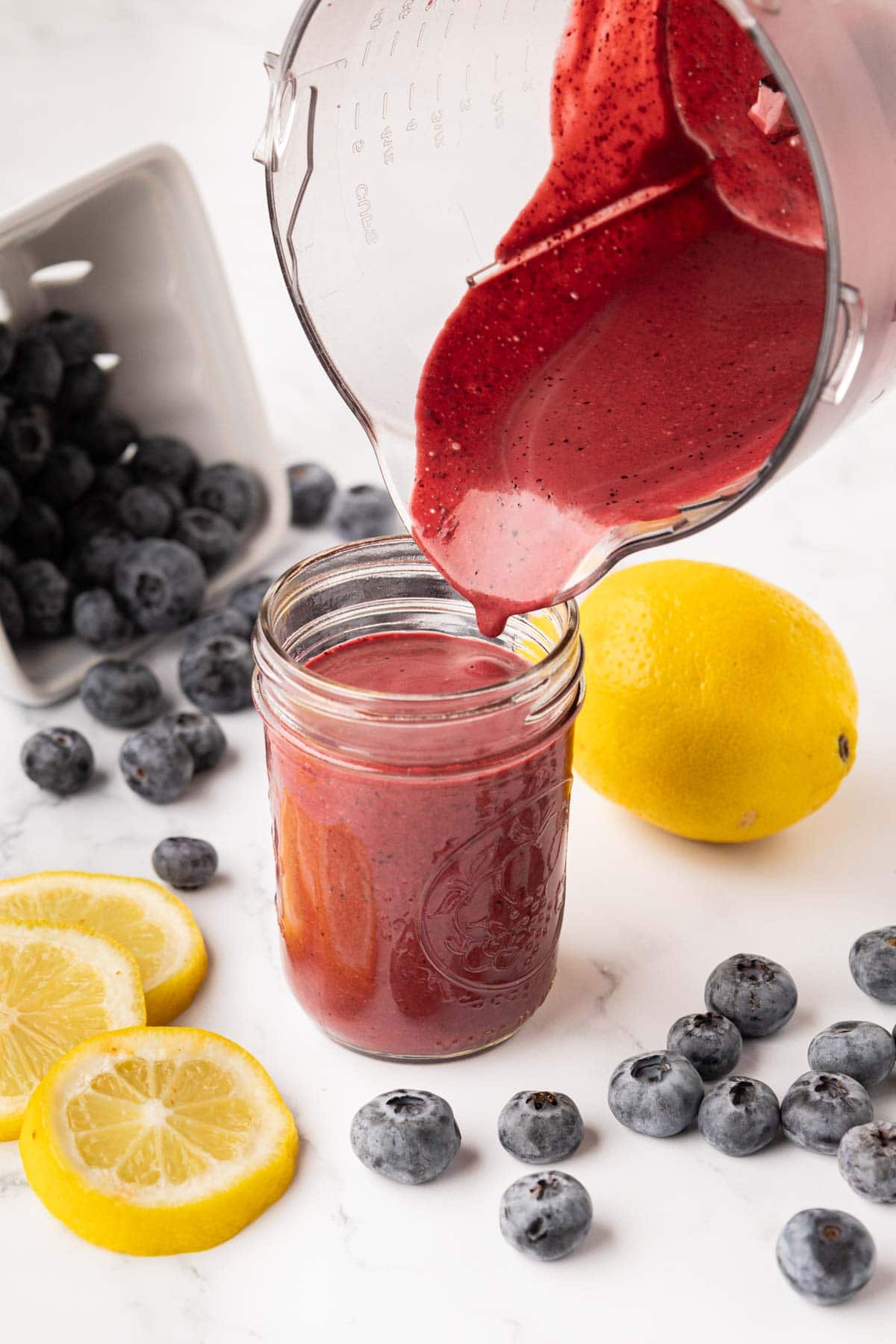 Pouring the dressing into a mason jar.