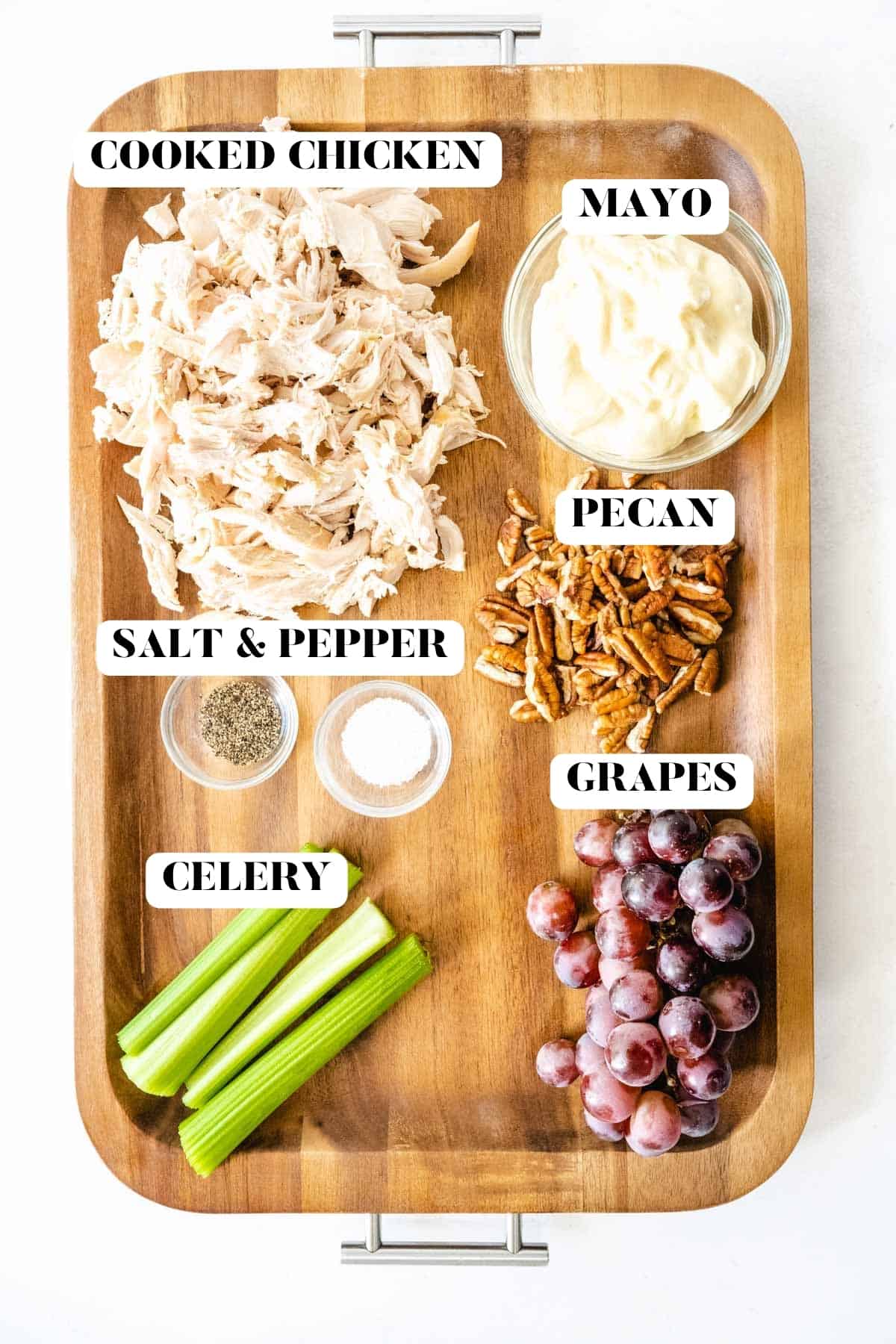 Chicken salad ingredients on a wooden tray labeled with text.