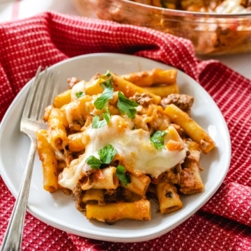 Creamy baked ziti pasta topped with melted parmesan and mozzarella cheeses.