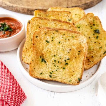 A plate full of homemade air fryer texas toast garlic bread on a white plate.