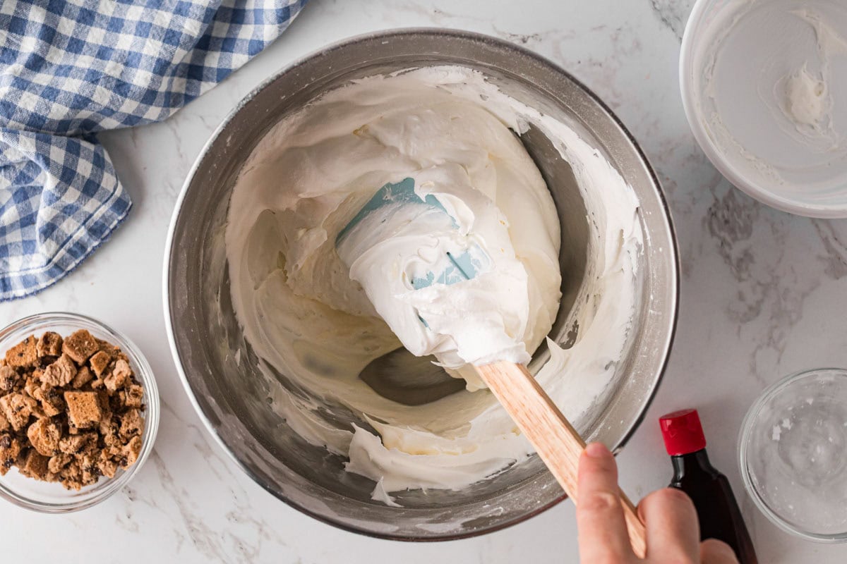 Folding whipped cream into cream cheese mixture.