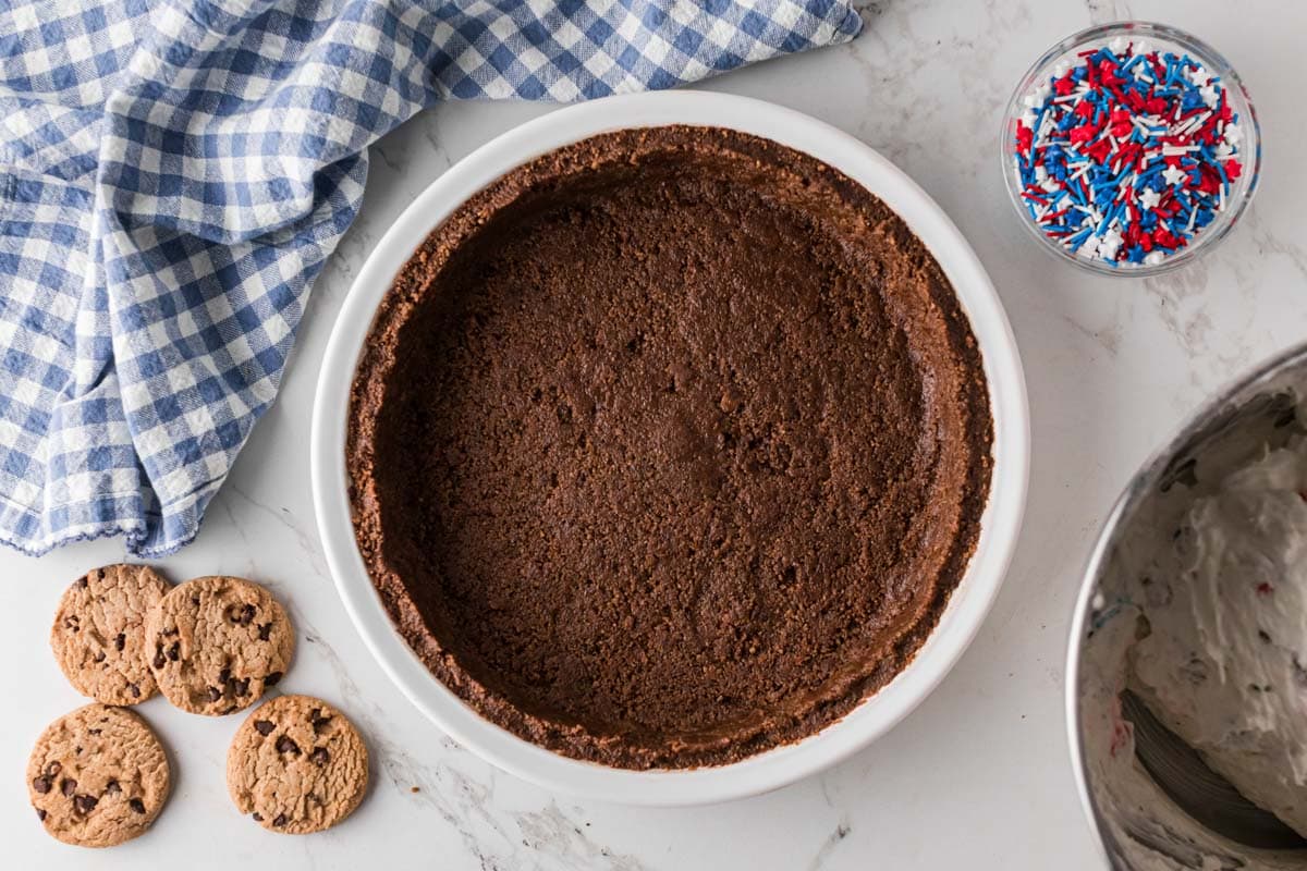 Chocolate chip cookie pie crust in a white pie dish.