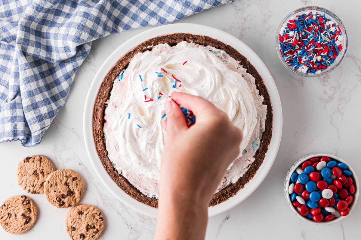 Adding festive sprinkles to top of the pie.