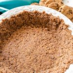 Chocolate Chip Cookie Crust in a white plate with chocolate chip cookies scattered in the background.