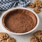 A no bake cookie pie crust in a white pie pan.
