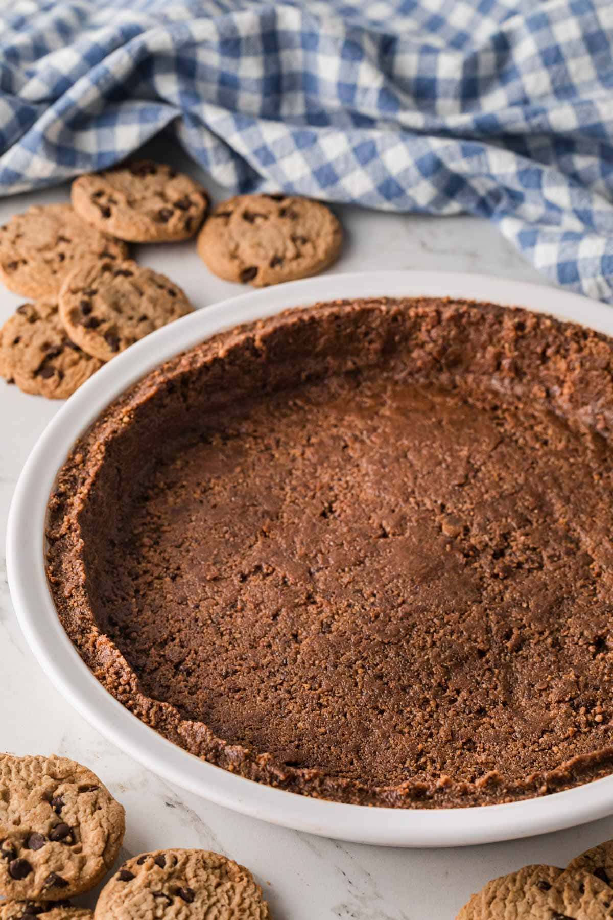 A no bake cookie pie crust in a white pie pan.