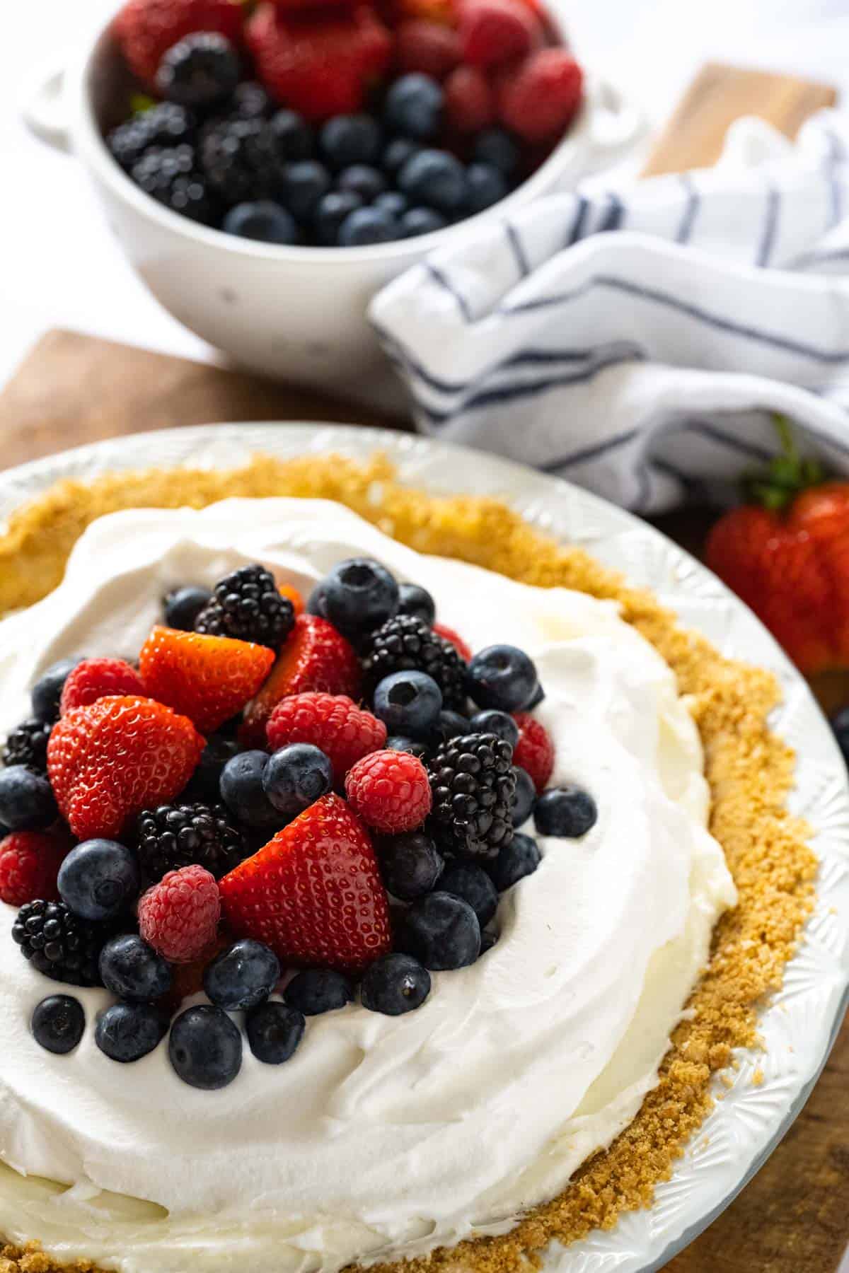 Red white and blueberry cream pie up close image of whole pie showing the layers with berries added to the top.