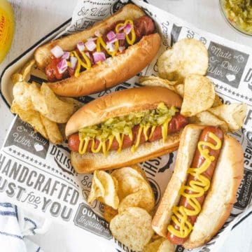 Air fryer hot dogs made three ways - one with mustard, one with mustard and relish, and one with ketchup, mustard and onions.