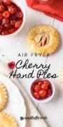 Air Fryer Cherry Hand Pies Pin 1 image with cherries and a hand pie featured on a counter with a plate full off to the corner