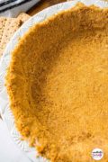 Up close image of a graham cracker pie crust with logo for pinterest.