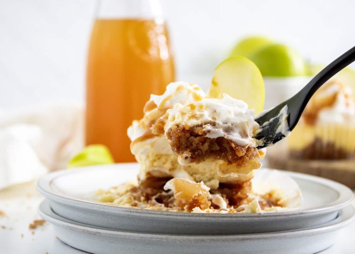 Mini apple cheesecake unwrapped and being eaten with a fork.