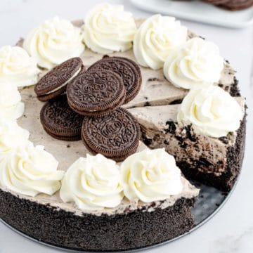 Upclose image of a whole no bake oreo cheesecake with a slice cut.