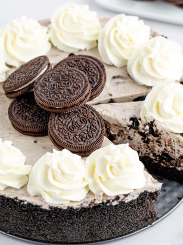 Upclose image of a whole no bake oreo cheesecake with a slice cut.