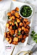 Pinterest image of sweet potato cubes on a white plate.