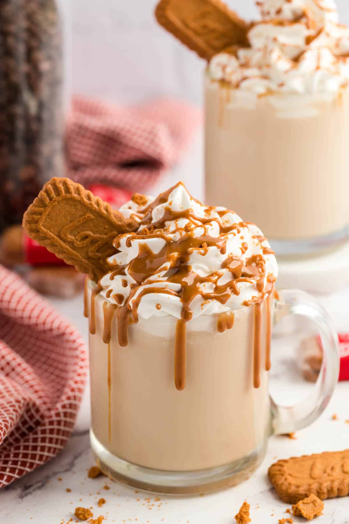 A Biscoff Latte with cookie butter drizzled down the rim of the glass coffee cup.