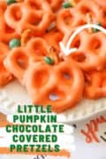 Pinterest image of a plate chocolate covered orange pumpkin pretzel.