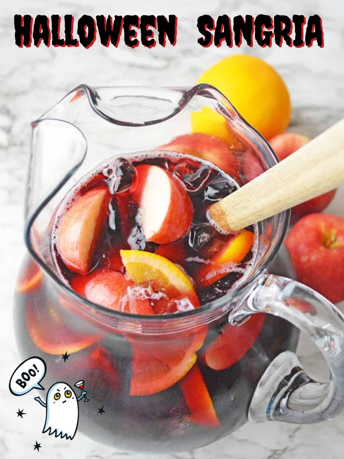 A pitcher of sangria with halloween decor around it.