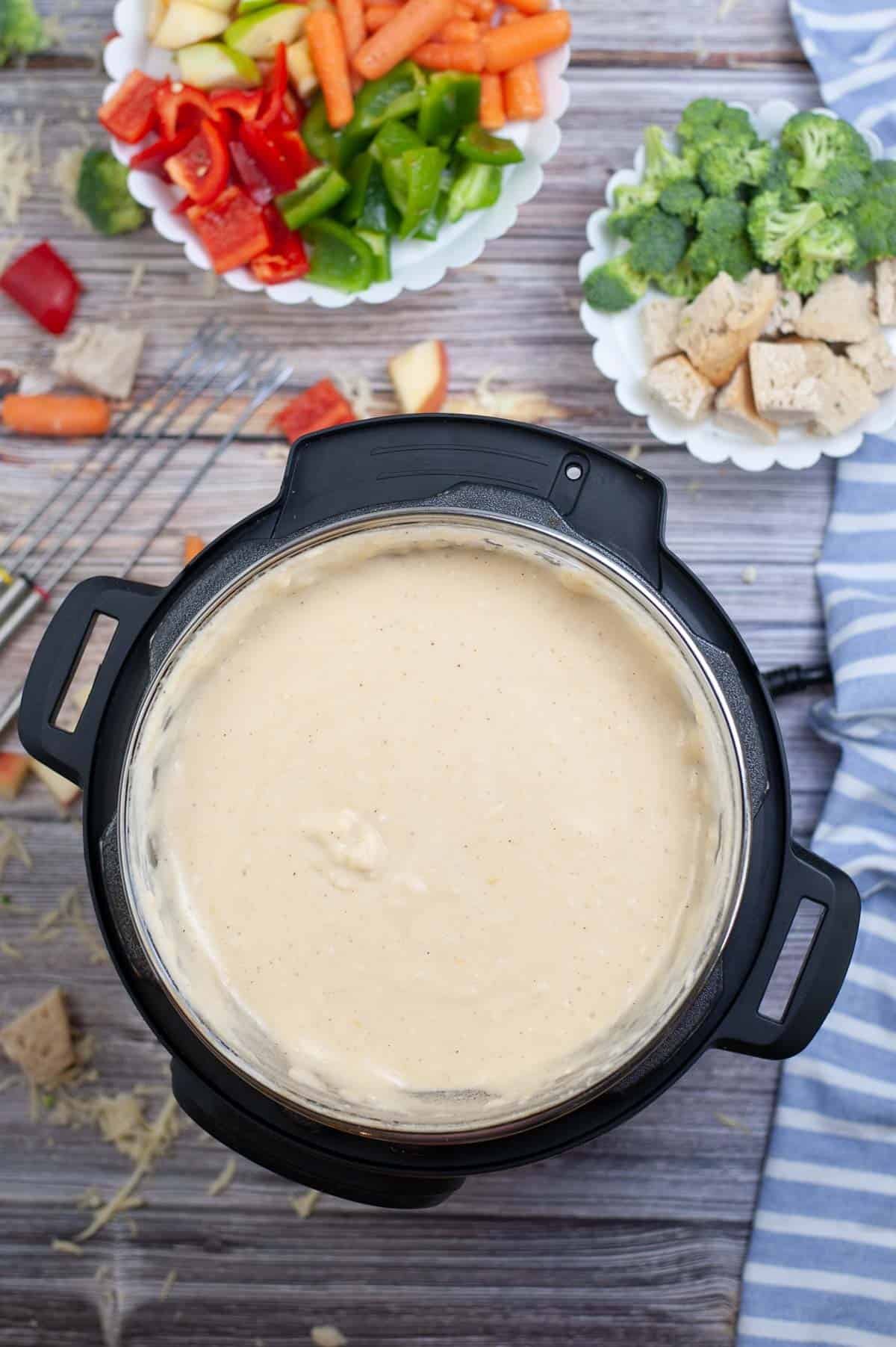 An overhead image of Instant Pot Cheese Fondue on a wooden table.