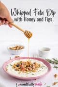 Whipped Feta Dip with honey and figs image of a honey spoon dripping honey into the pink bowl of dip
