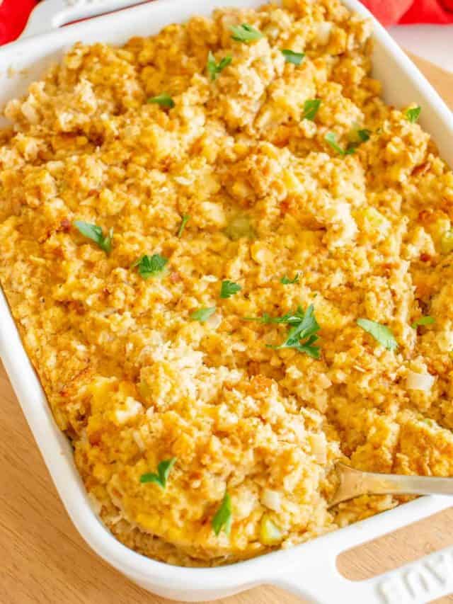 A pan full of a simple cornbread dressing garnished with parsley.
