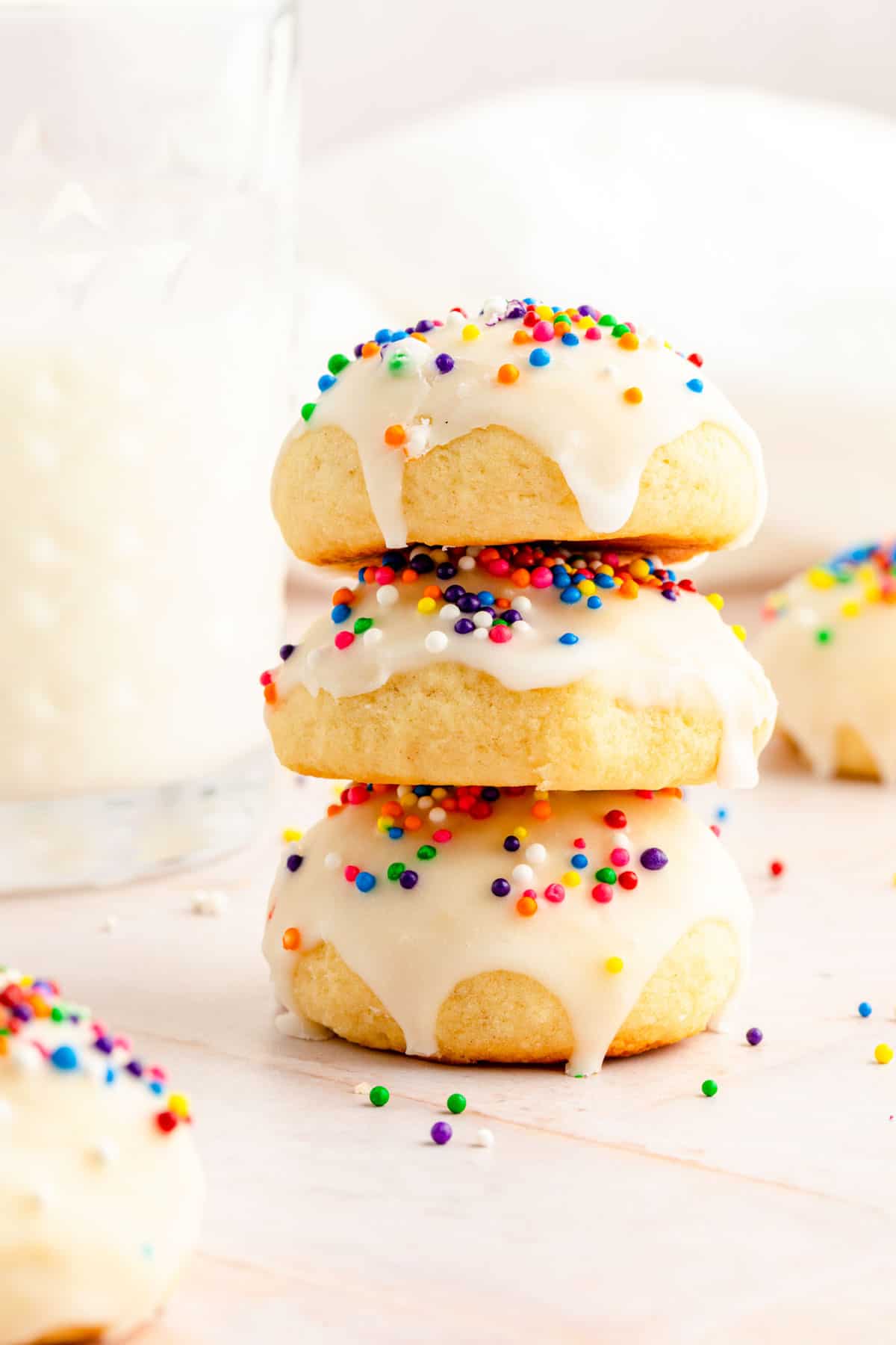 Three stacked Italian ricotta cookies beautifully glazed and topped with bright sprinkles.