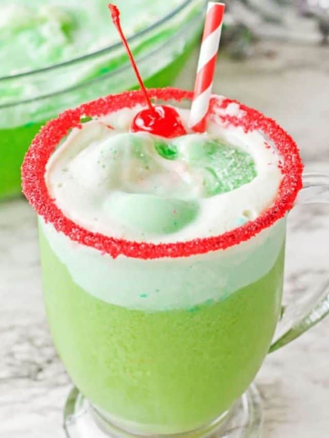 Grinch punch recipe rimmed with red sugar in a glass.