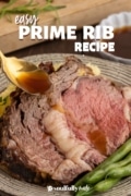 Easy prime rib recipe plated with beans and gravy in a spoon dripping over.