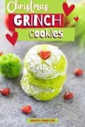 Pinterest image with three grinch cookies stacked on a gray marble table.