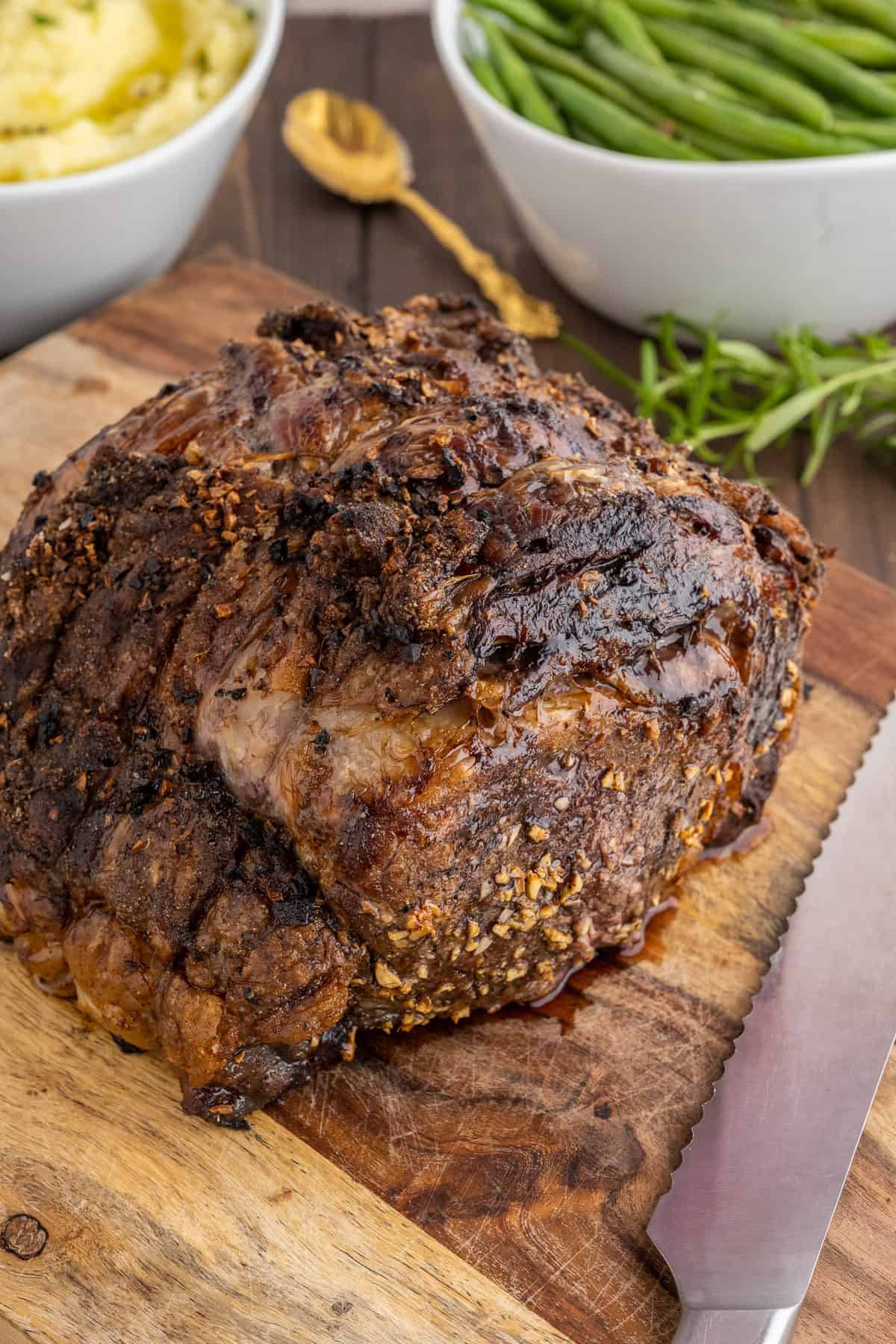 A perfectly cooked prime rib resting on a cutting board.