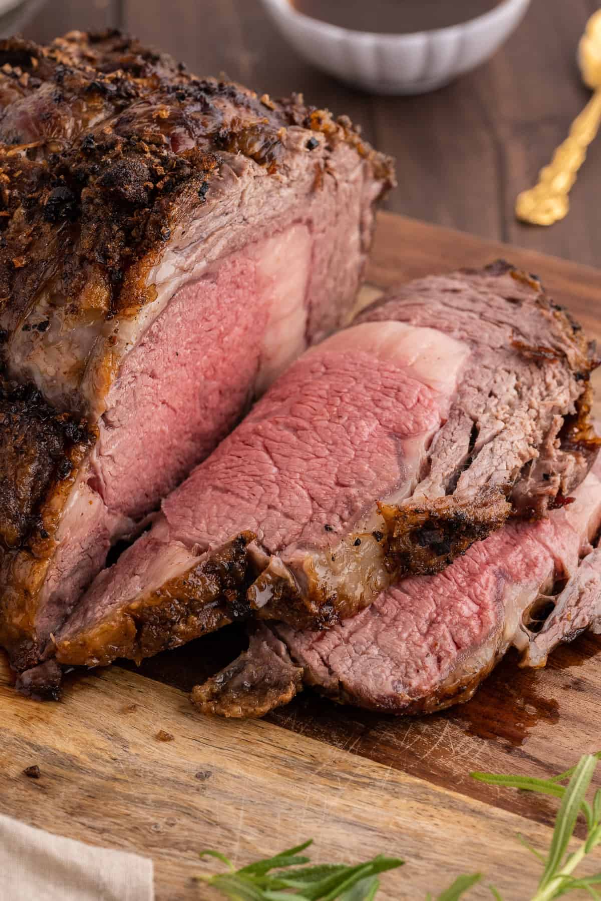 A sliced standing rib roast on a wood cutting board.