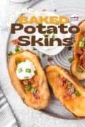 Bite-sized perfection-- Loaded Baked Potato Skins are deliciously crispy baked potatoes with a garlicky seasoned outside, loaded with melted cheese and crunchy bacon, and then topped with sour cream and green onions!