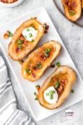 This Loaded Baked Potato Skins Recipe is just in time for the Big Game, tailgating, appetizers, snacks, and so much more! They are an all-time favorite loaded with cheese, bacon, sour cream, and green onions!