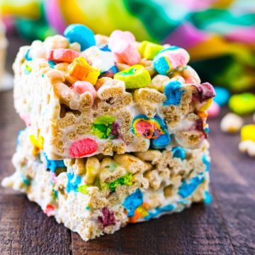 Two stacked lucky charms treats stacked on a wooden tray.