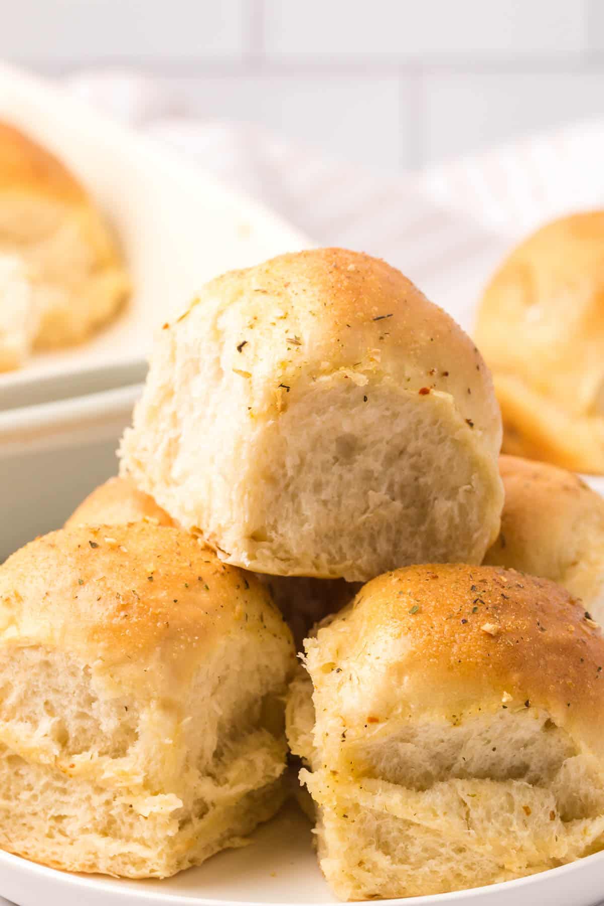 A white plate filled with buttery rolls.
